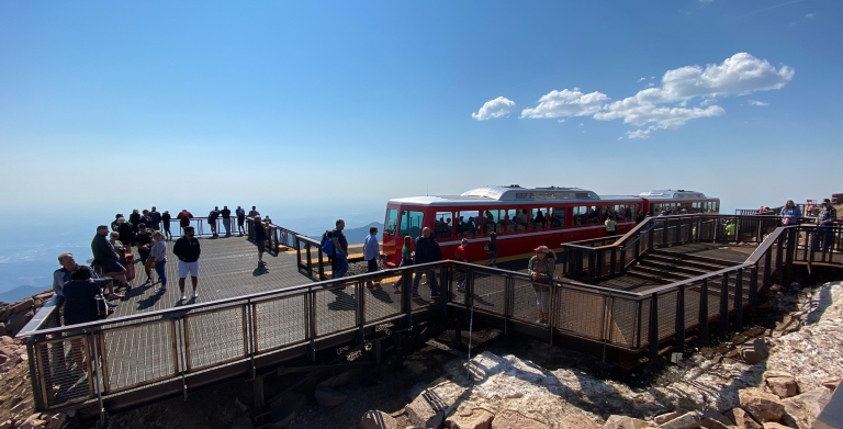 Platform with passengers departing train on top of mountain