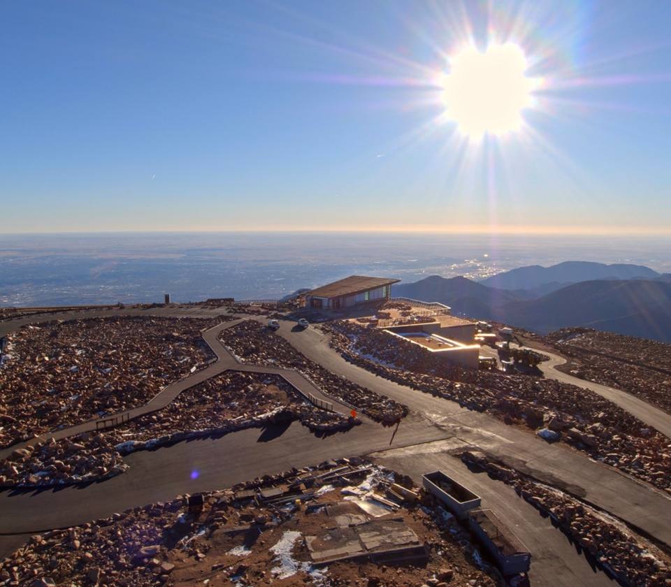 sunrise on top of mountain with building